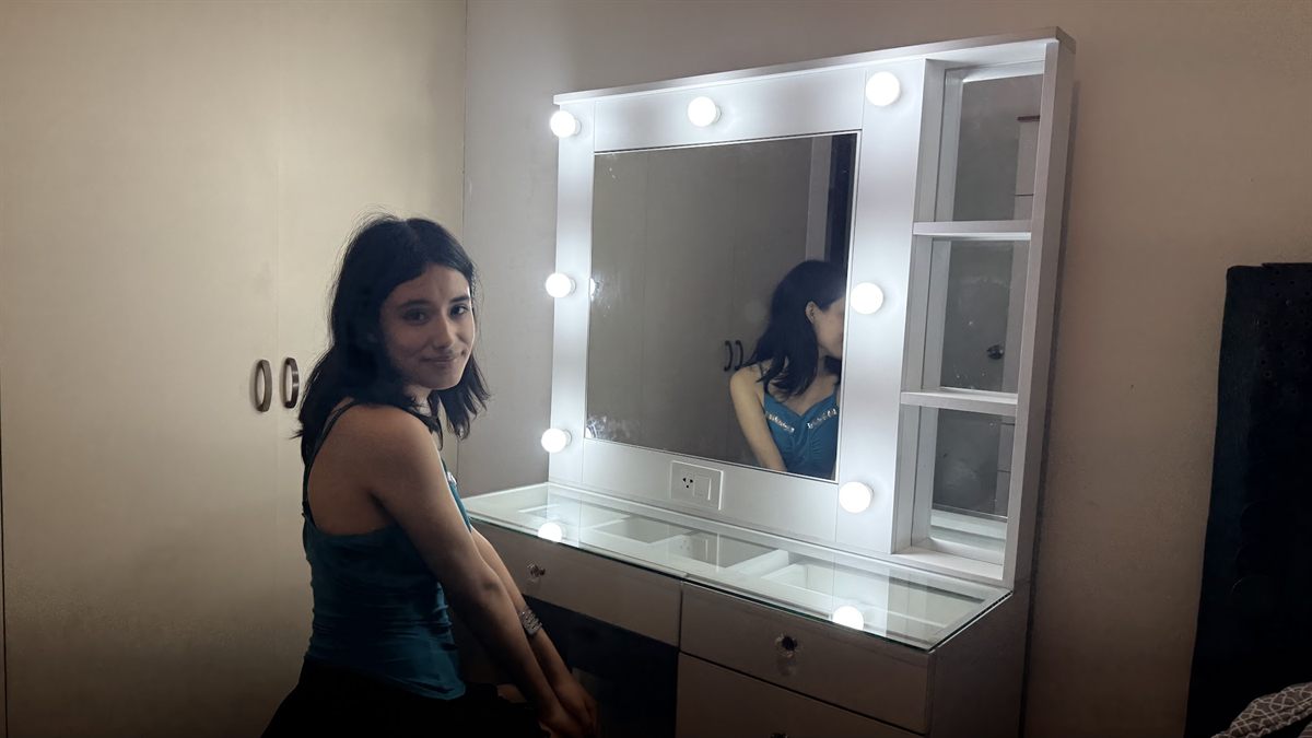 Gabi frente a un espejo con luces